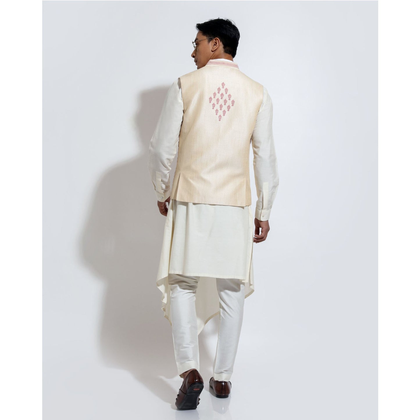 Sleeveless bandi with linear motif couching embroidery layered over assymetric hem kurta