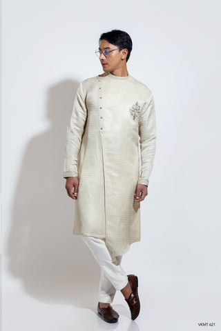 Assymetric hem jacquard kurta with badge embroidery layered over crop pants
